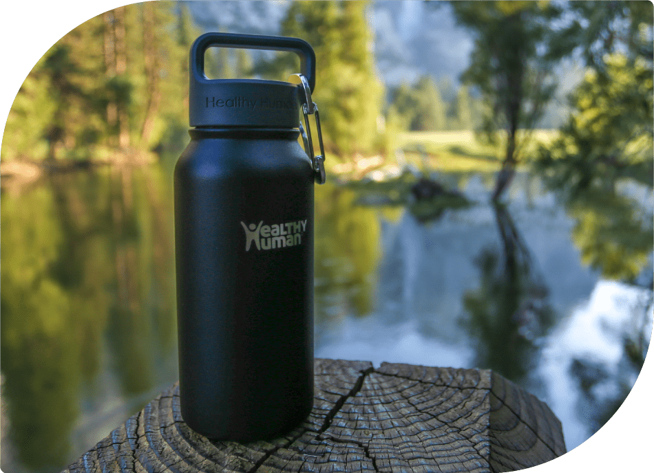 Healthy Human Bottle Resting on a Halved Tree Trunk in Nature - Harmonizing with Water and Trees