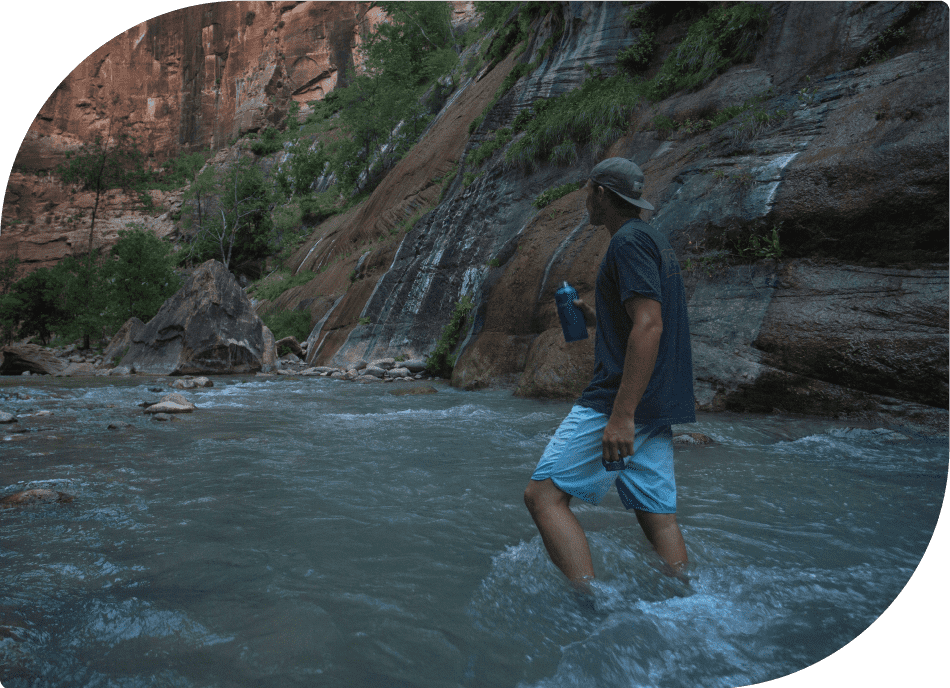 Man Holding Healthy Human Bottle - Refreshing Hydration by the Water's Edge
